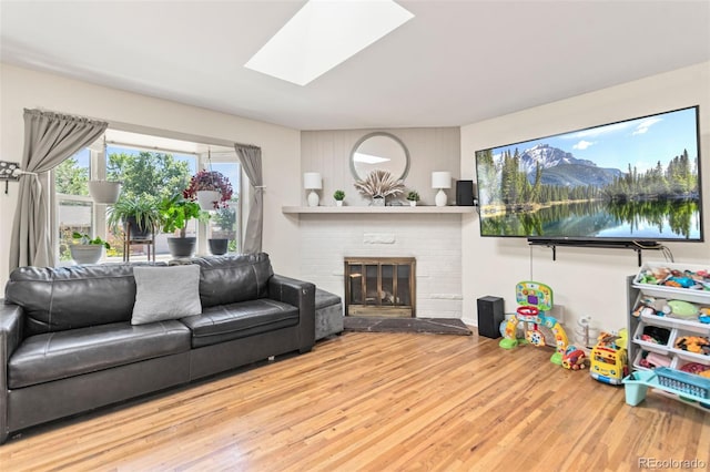 3397 W Tanforan Dr, Englewood, CO 80110 - living area featuring wood finished floors, a brick fireplace, and a skylight