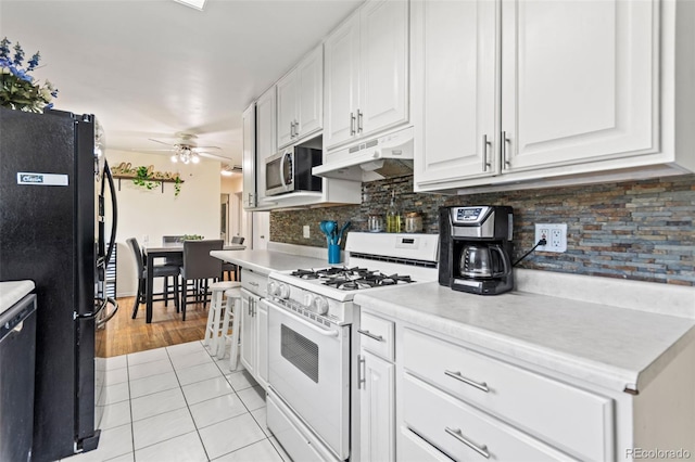 3397 W Tanforan Dr, Englewood, CO 80110 - kitchen featuring white gas range oven, freestanding refrigerator, under cabinet range hood, light tile patterned floors, and ceiling fan