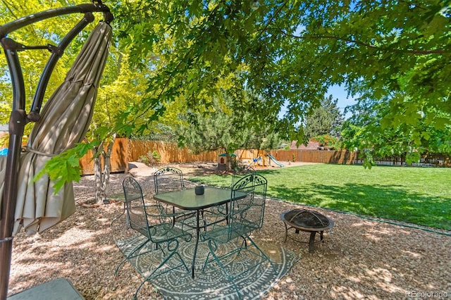 3397 W Tanforan Dr, Englewood, CO 80110 - fenced backyard with a playground, a fire pit, and a patio area