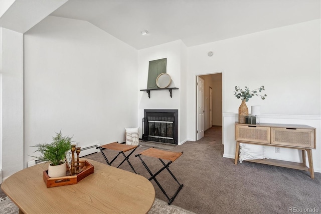 carpeted living room featuring vaulted ceiling and a baseboard heating unit