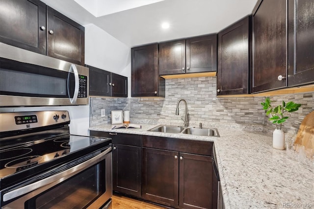 kitchen featuring decorative backsplash, stainless steel appliances, sink, and dark brown cabinets