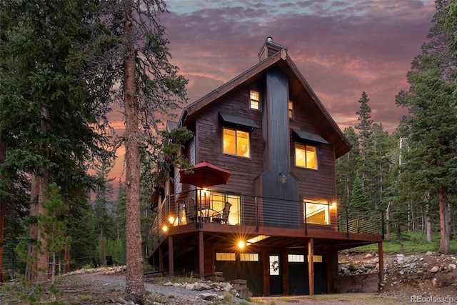 back house at dusk with a deck