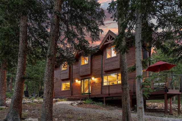 back house at dusk with a deck