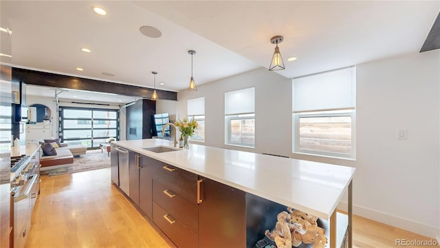 2147 S Sherman St, Denver, CO 80210 - kitchen with light wood-style floors, pendant lighting, open floor plan, recessed lighting, and light countertops