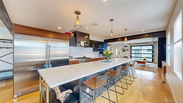 2147 S Sherman St, Denver, CO 80210 - kitchen with high quality appliances, light wood finished floors, light countertops, a breakfast bar, and a large island with sink