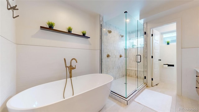 2147 S Sherman St, Denver, CO 80210 - bathroom featuring a soaking tub, a shower stall, tile patterned floors, tile walls, and vanity