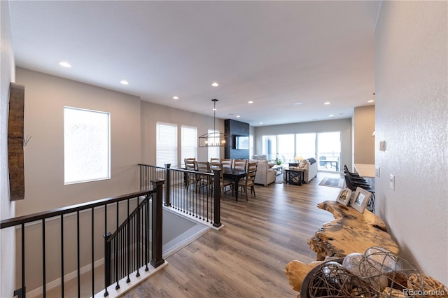 hall with an inviting chandelier and hardwood / wood-style flooring