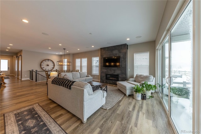 living room featuring light wood-type flooring and a tiled fireplace