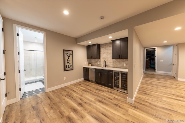 bar featuring dark brown cabinetry, light hardwood / wood-style floors, decorative backsplash, sink, and stainless steel dishwasher