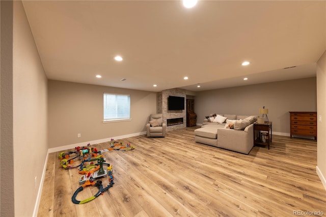 living room featuring light hardwood / wood-style floors and a large fireplace