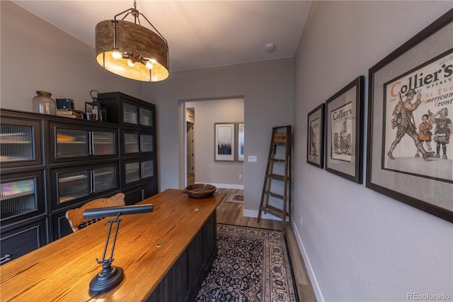 home office with baseboards and dark wood-type flooring