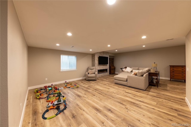 living room with a large fireplace, baseboards, wood finished floors, and recessed lighting