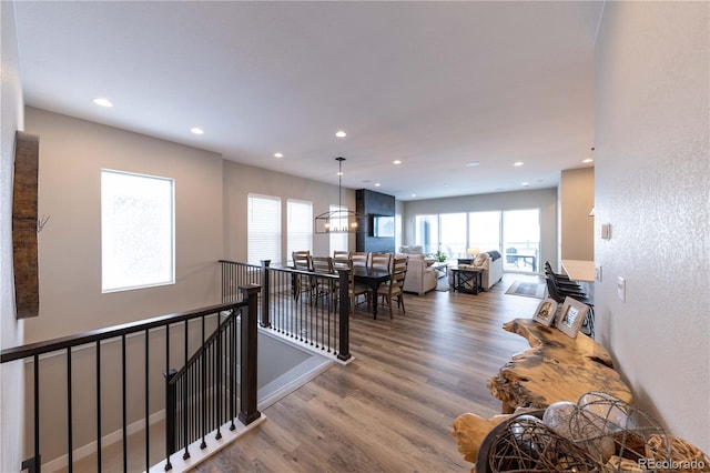 hall featuring recessed lighting, an upstairs landing, and wood finished floors