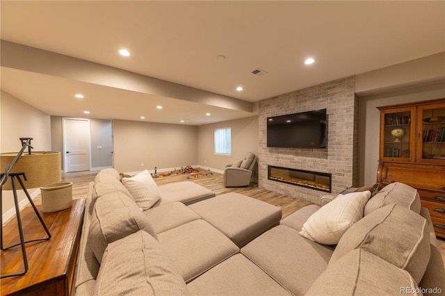 living area with recessed lighting, a fireplace, wood finished floors, visible vents, and baseboards