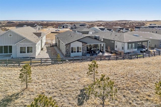 back of property with a residential view and fence