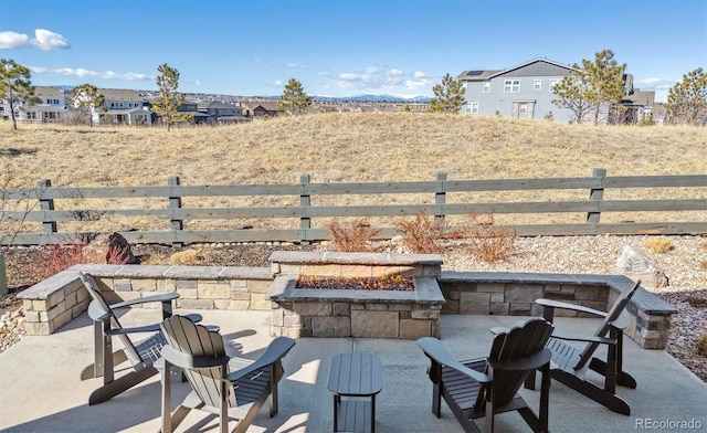 view of patio with an outdoor fire pit and fence
