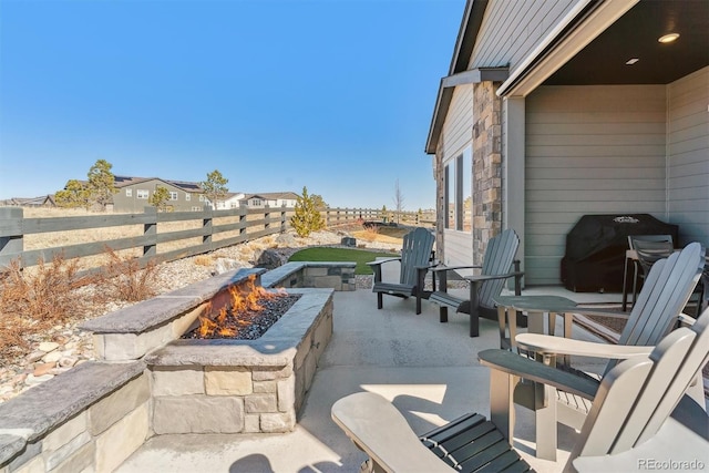 view of patio featuring an outdoor fire pit, fence, and area for grilling