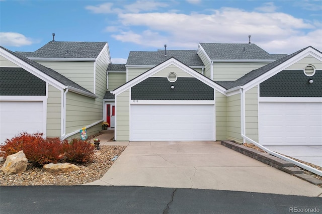 3338 Soaring Bird Cir, Colorado Springs, CO 80920 - townhome / multi-family property with roof with shingles, concrete driveway, and a garage