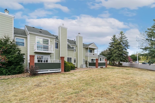 3338 Soaring Bird Cir, Colorado Springs, CO 80920 - rear view of property featuring a lawn, a balcony, and a chimney