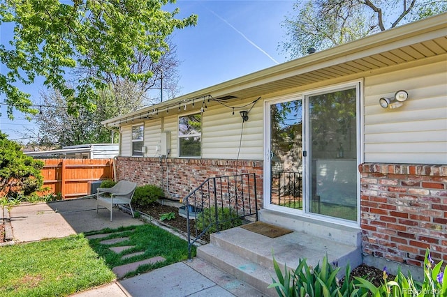 4781 S Grant St, Englewood, CO 80113 - doorway to property with brick siding, fence, and a patio