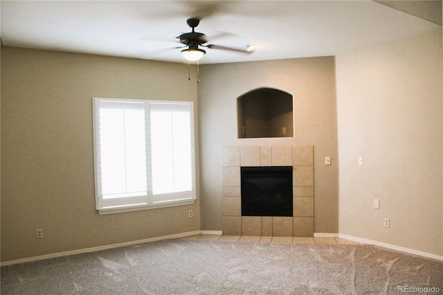 unfurnished living room featuring a fireplace, ceiling fan, and carpet