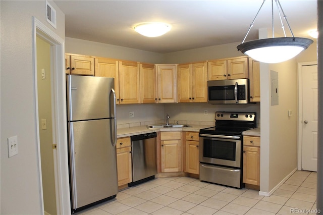 kitchen featuring sink, light tile patterned floors, appliances with stainless steel finishes, electric panel, and light brown cabinetry