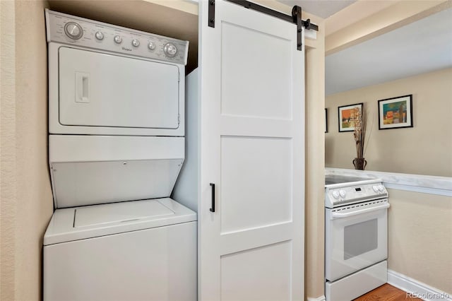 2813 Jasmine St, Denver, CO 80207 - laundry area with stacked washer / drying machine, a barn door, and baseboards