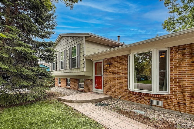 117 Sandler Dr, Lafayette, CO 80026 - view of exterior entry with brick siding and a yard