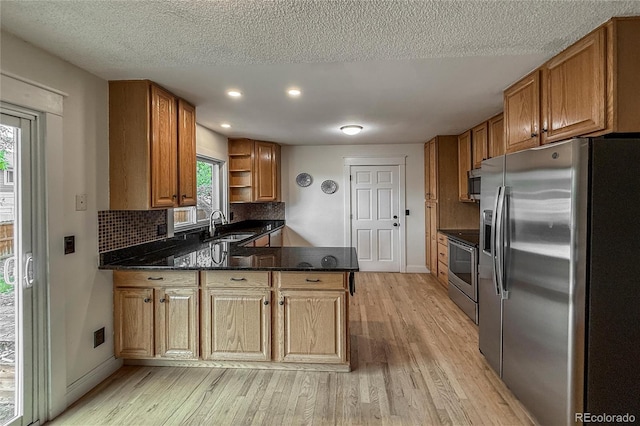 117 Sandler Dr, Lafayette, CO 80026 - kitchen with stainless steel appliances, a sink, light wood-style floors, a peninsula, and open shelves