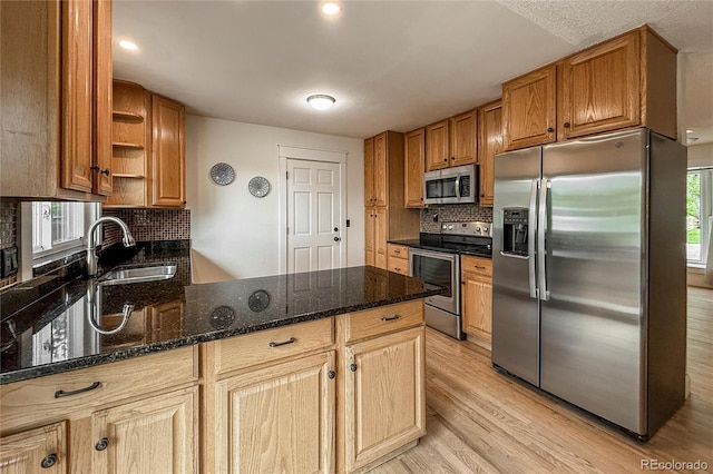 117 Sandler Dr, Lafayette, CO 80026 - kitchen featuring appliances with stainless steel finishes, a peninsula, open shelves, a sink, and decorative backsplash