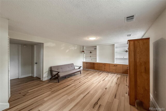 117 Sandler Dr, Lafayette, CO 80026 - living area featuring light wood-style floors, a textured ceiling, baseboards, baseboard heating, and built in features