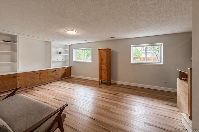 117 Sandler Dr, Lafayette, CO 80026 - unfurnished bedroom with multiple windows, baseboards, light wood-style floors, and a textured ceiling