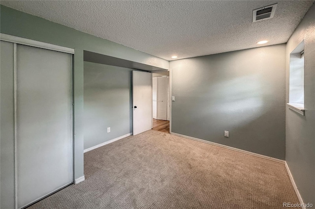 117 Sandler Dr, Lafayette, CO 80026 - unfurnished bedroom with carpet, a textured ceiling, baseboards, multiple closets, and recessed lighting