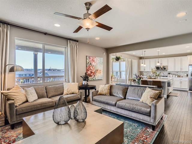 11096 Endeavor Dr, Parker, CO 80134 - living area with a ceiling fan, recessed lighting, dark wood-style flooring, and a textured ceiling