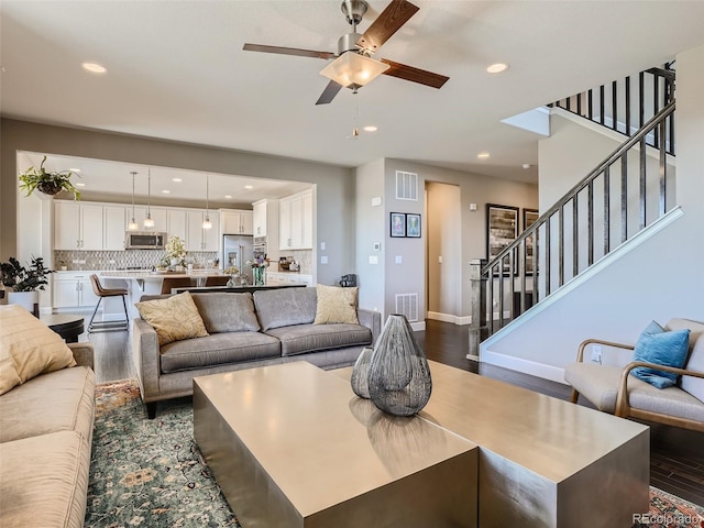 11096 Endeavor Dr, Parker, CO 80134 - living area with dark wood-style floors, a ceiling fan, recessed lighting, stairs, and baseboards