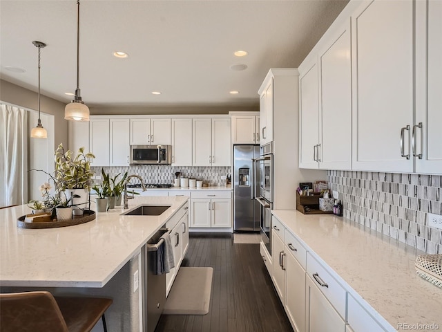 11096 Endeavor Dr, Parker, CO 80134 - kitchen with stainless steel appliances, a sink, white cabinetry, recessed lighting, and backsplash