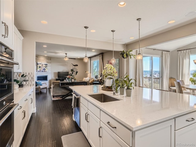 11096 Endeavor Dr, Parker, CO 80134 - kitchen featuring a sink, open floor plan, healthy amount of natural light, a center island with sink, and recessed lighting