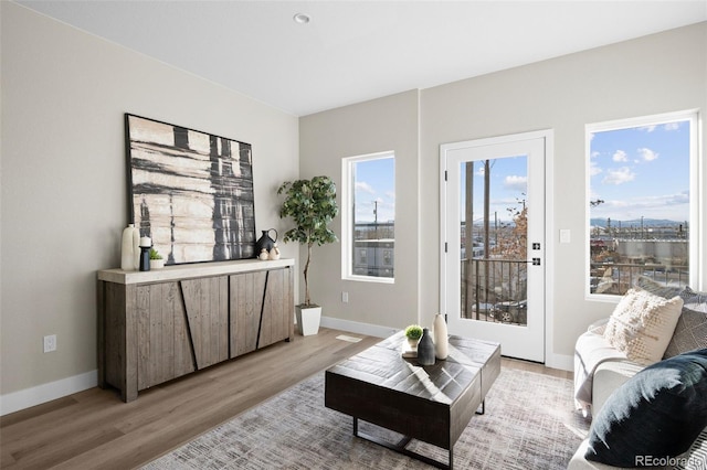 living area featuring light wood-style floors and baseboards