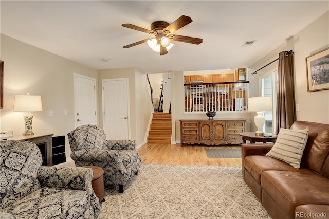 12671 Meadow Bridge Way, Parker, CO 80134 - living room featuring light wood finished floors, stairs, a ceiling fan, and baseboards
