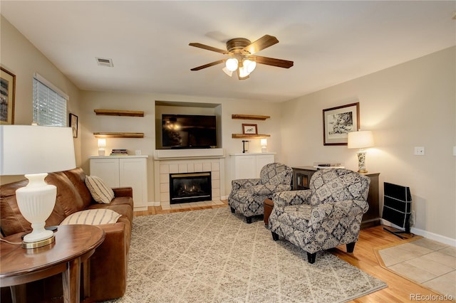12671 Meadow Bridge Way, Parker, CO 80134 - living room with ceiling fan, a tiled fireplace, wood finished floors, and baseboards