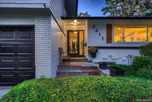 property entrance featuring brick siding and an attached garage