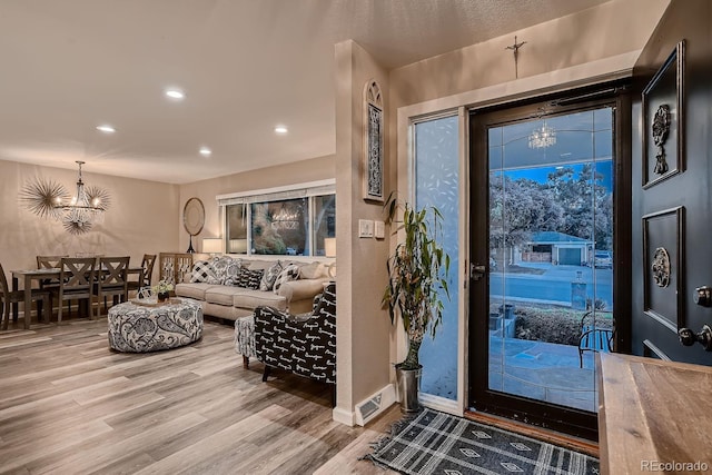 entryway featuring an inviting chandelier, recessed lighting, baseboards, and wood finished floors