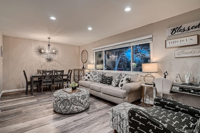 living room with baseboards, recessed lighting, wood finished floors, and a notable chandelier