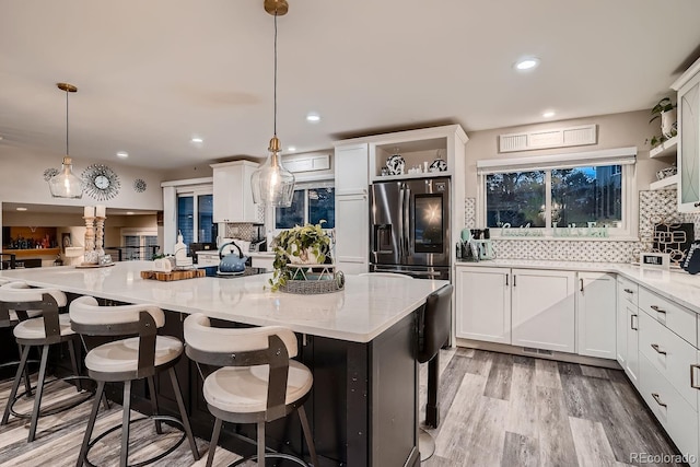 kitchen with backsplash, white cabinetry, open shelves, and stainless steel fridge with ice dispenser