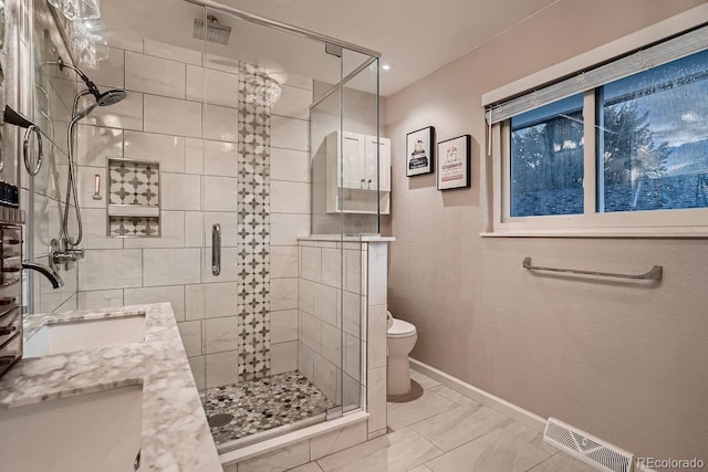 full bathroom with a sink, a stall shower, toilet, and visible vents