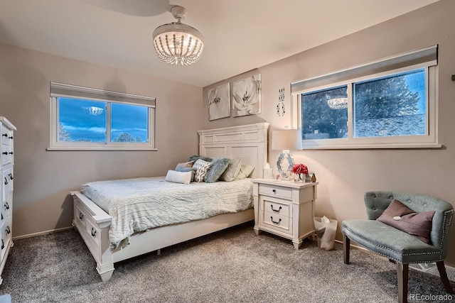 carpeted bedroom with a notable chandelier