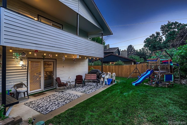 view of yard with an outdoor living space, fence, a balcony, a playground, and a patio