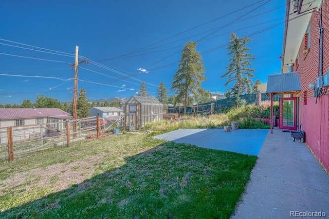 view of yard with a storage unit and a patio area