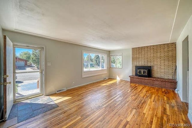 unfurnished living room with light wood-type flooring and a fireplace