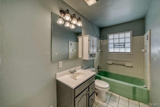 full bathroom featuring tile patterned flooring, tiled shower / bath combo, vanity, and toilet